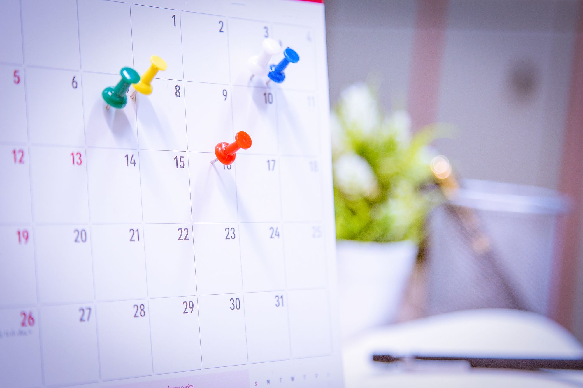 Photo d'un calendrier avec des punaises pour indiquer des événements prévus